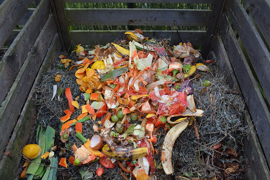 Wooden Compost Bin Filled With Vegetable Scraps And Organic Waste