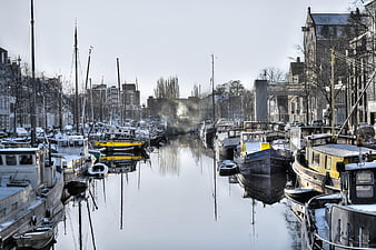 Snowy Canal in Groningen with Moored Boats and Reflections