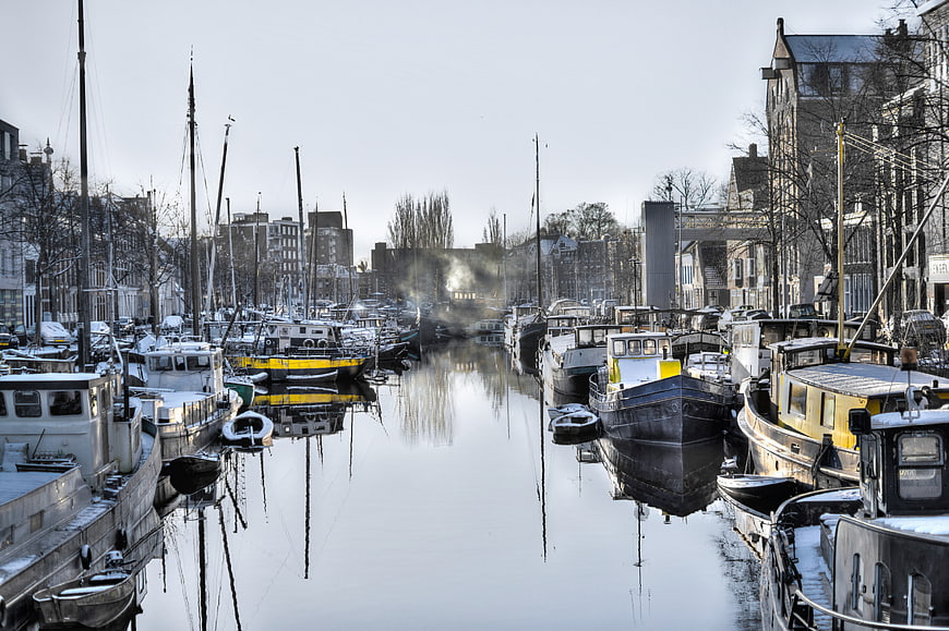 Snowy Canal in Groningen with Moored Boats and Reflections