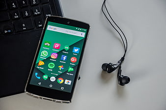 Smartphone with social media apps and headphones on desk