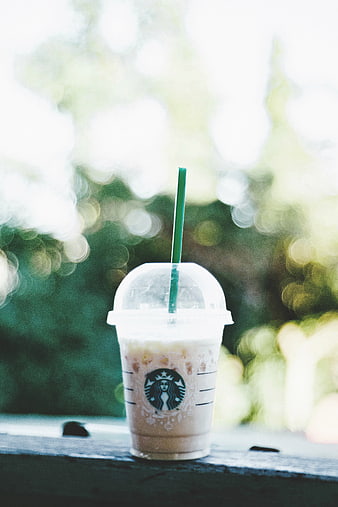 Iced Starbucks Frappuccino with Green Straw on Wooden Surface