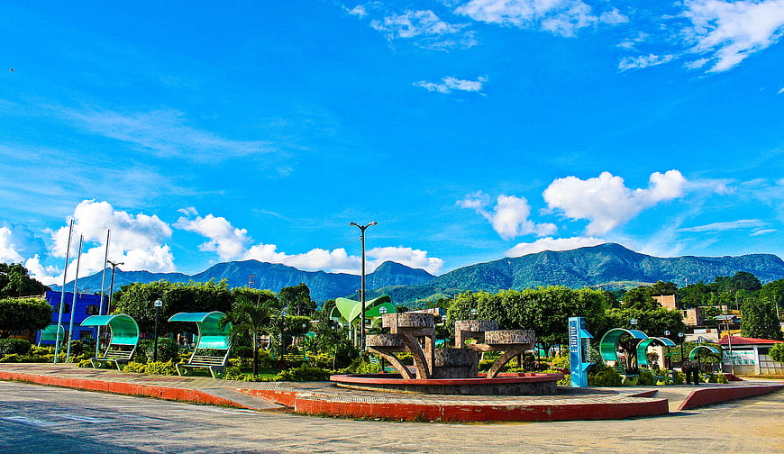 Vibrant Town Square with Monument and Mountain Backdrop