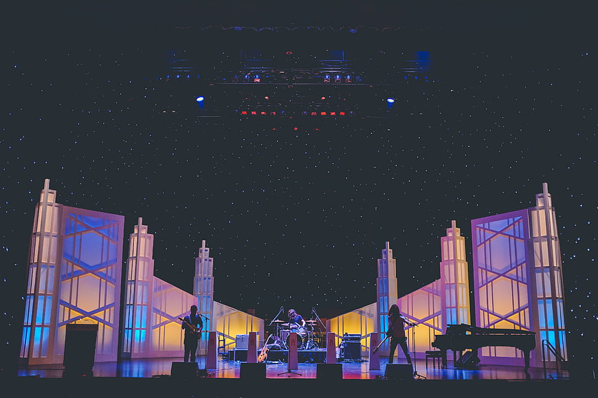 Band performing on stage with futuristic cityscape backdrop