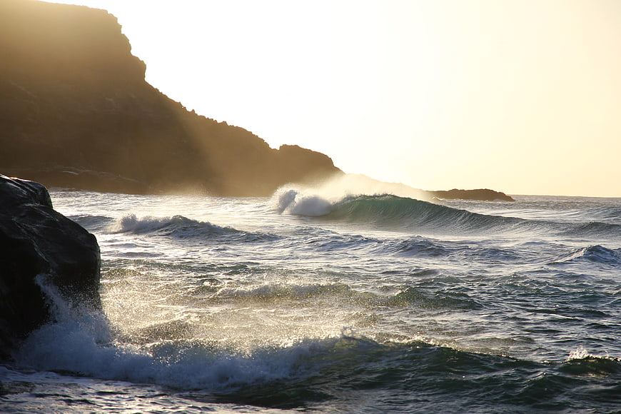 Ocean Waves Crashing Against Rocky Cliffs at Golden Hour