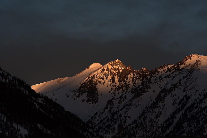 Snow-Capped Mountain Peak Illuminated by Golden Hour Sunlight