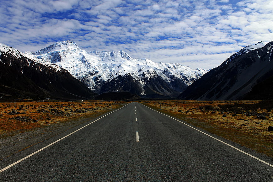 Asphalt Road Leading to Snowy Mountains