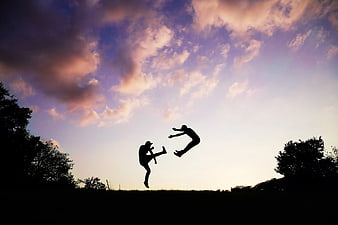 Silhouette of Two Martial Artists Sparring at Sunset