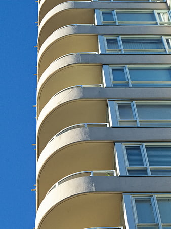Curved Modern Apartment Building Facade Against Blue Sky