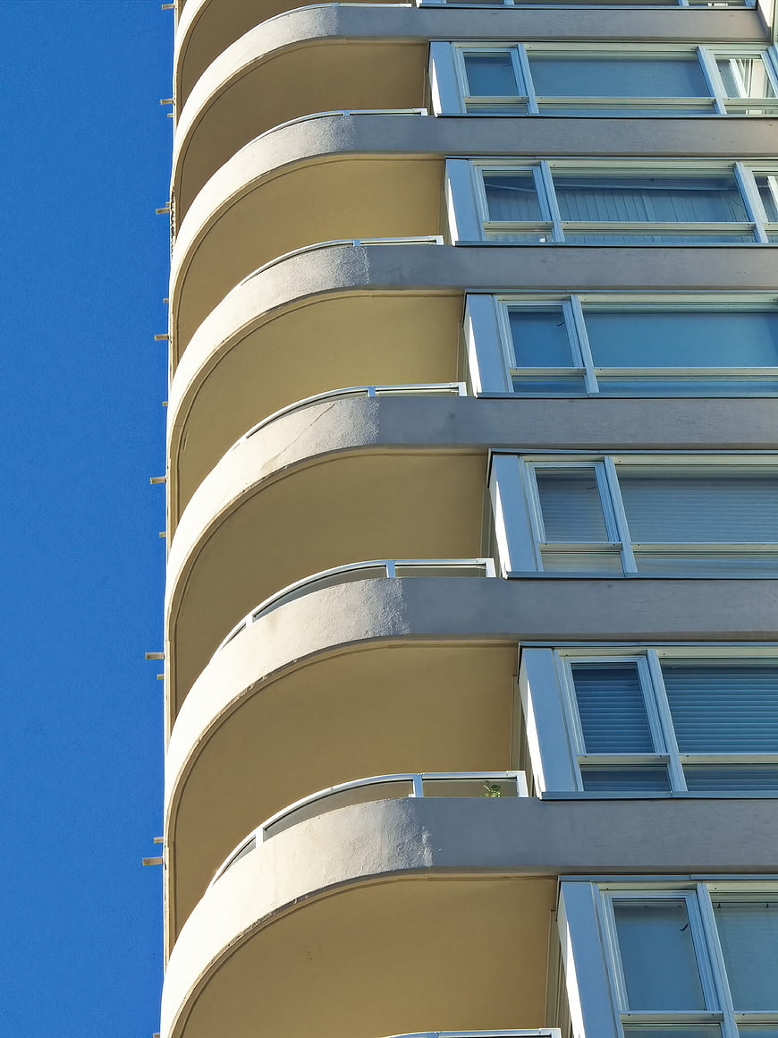 Curved Modern Apartment Building Facade Against Blue Sky