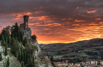 Dramatic sunset over medieval tower in Italian hill town