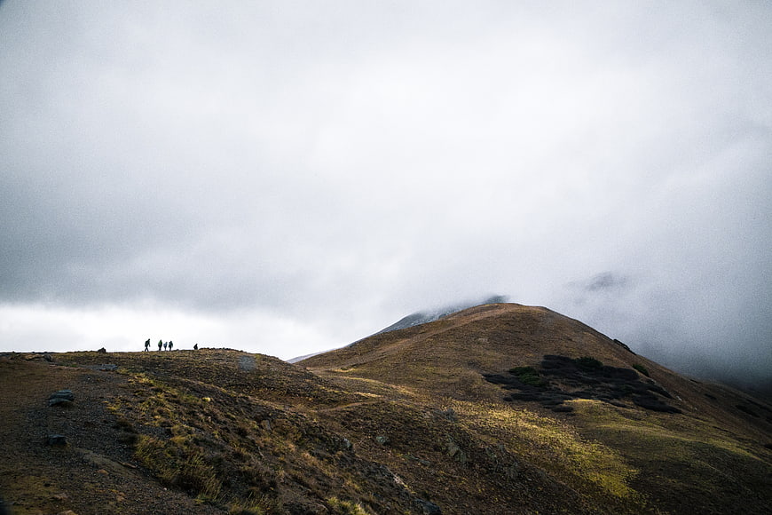 Hikers on a Misty Mountain Ridge Under Overcast Sky
