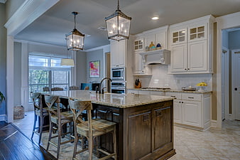 Modern kitchen with white cabinets and dark wood island