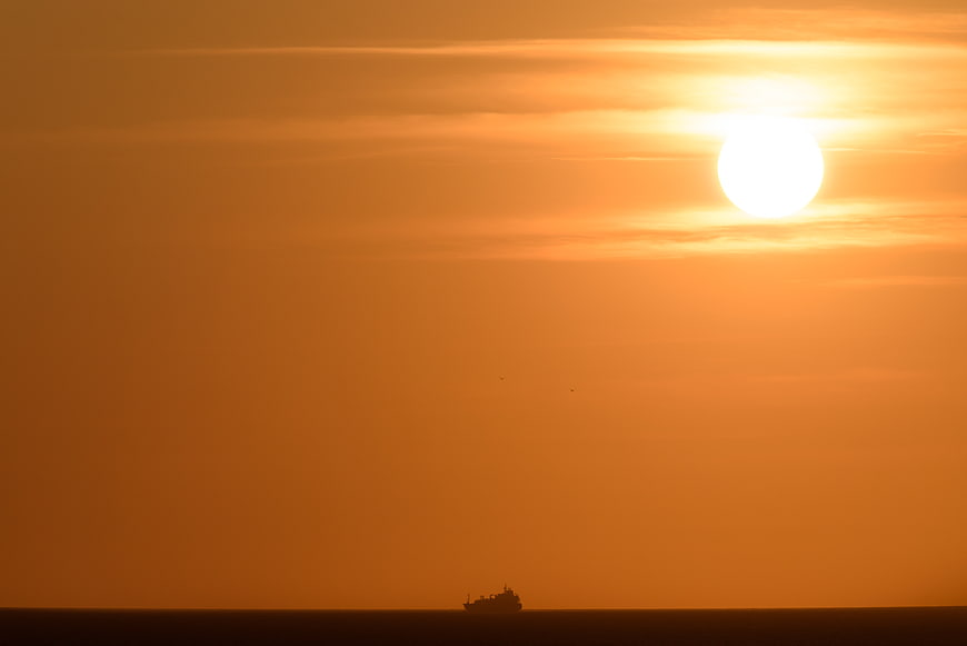 Silhouette of a ship on the ocean during a golden sunset