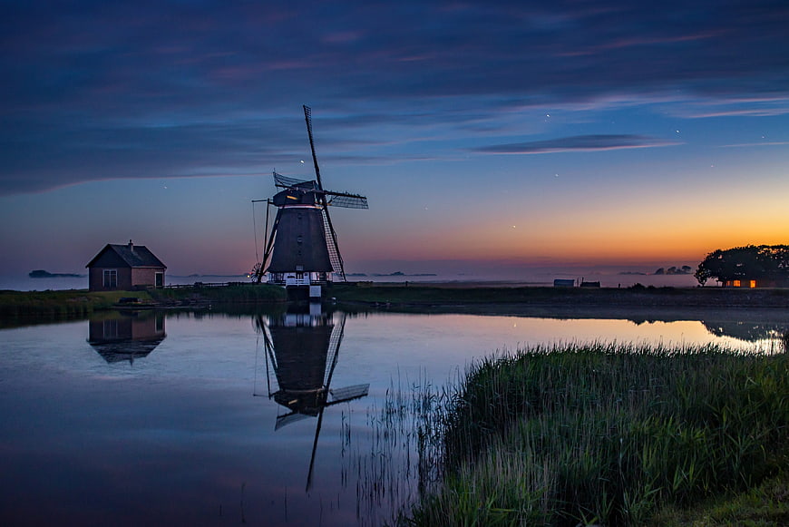 Dutch Windmill Reflection at Dusk with Stars and Orange Horizon