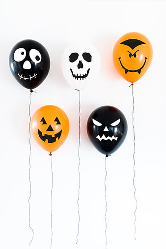 Halloween balloons with spooky faces on white background