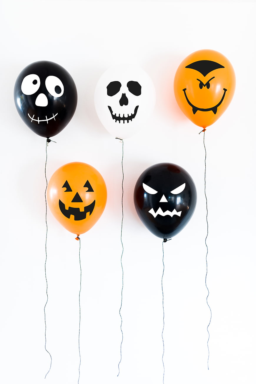 Halloween balloons with spooky faces on white background