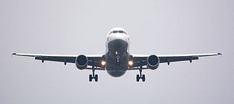 Frontal view of commercial airliner landing with landing gear down