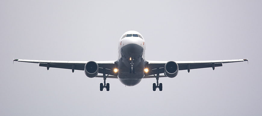 Frontal view of commercial airliner landing with landing gear down