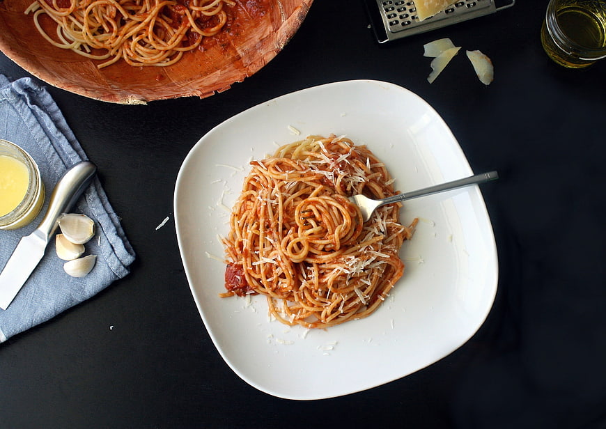 Spaghetti with tomato sauce and parmesan cheese on a white plate
