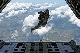 Soldier Freefalling From Military Aircraft Over Clouds