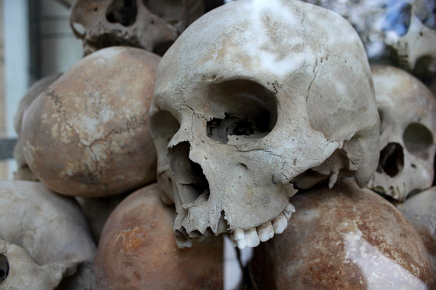 Close-up of weathered human skulls stacked in a historical memorial