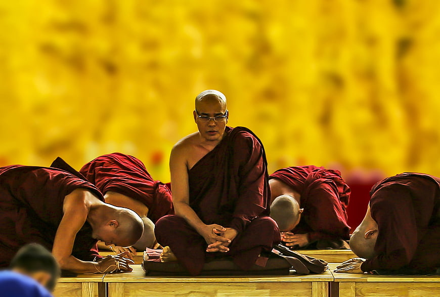 Theravada Buddhist Monks Prostrating in Prayer at Monastery