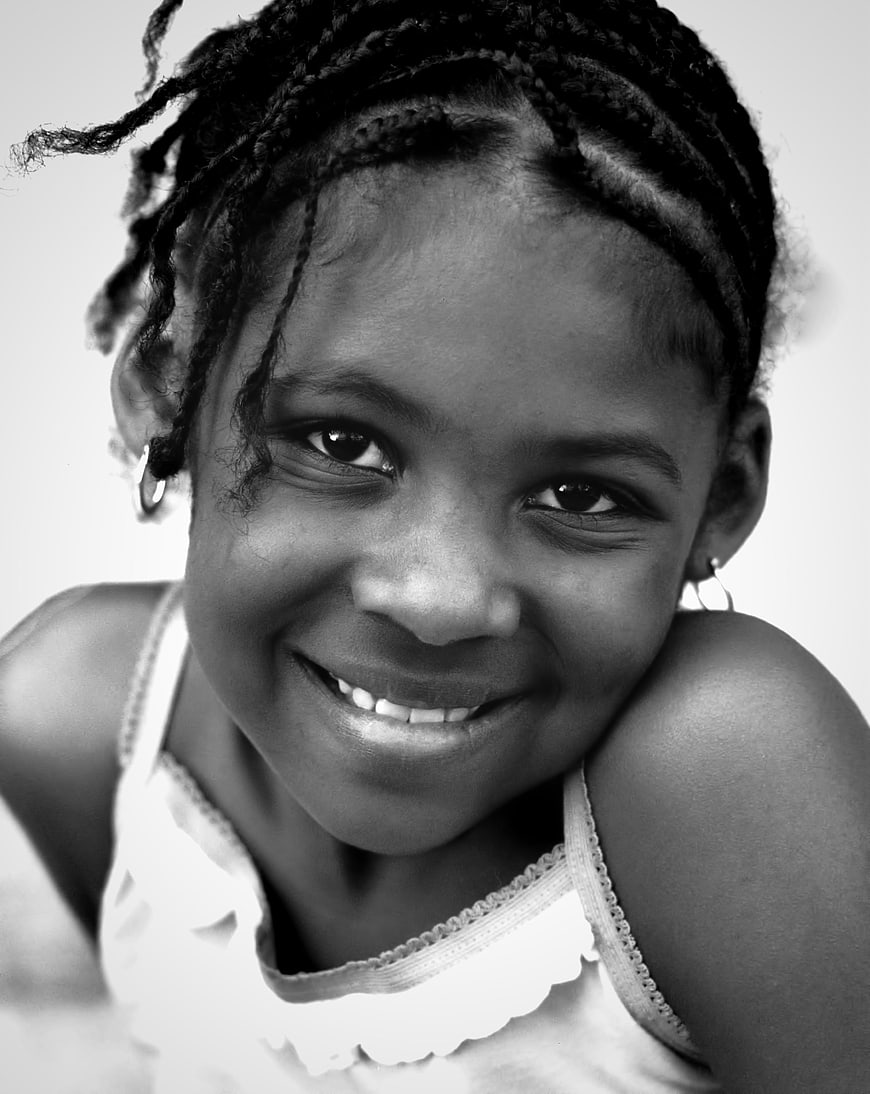 Black and white portrait of smiling young girl with braids
