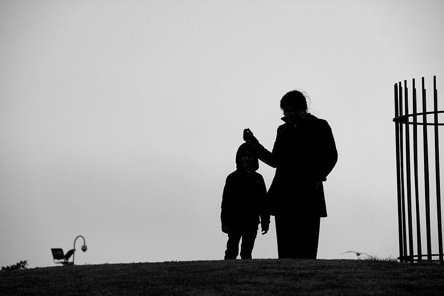Silhouette of Mother and Child Standing in Park