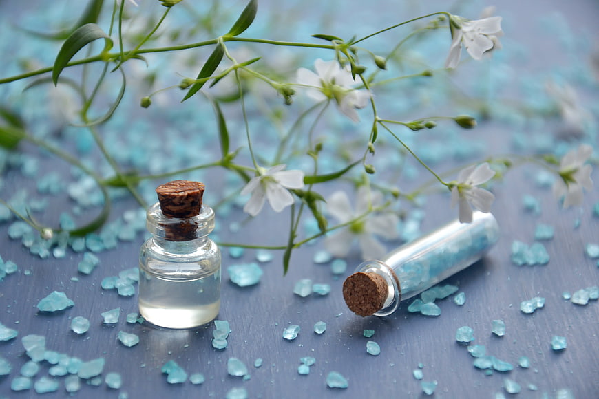 Essential Oil Bottles with Blue Crystals and White Flowers