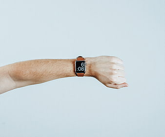 Man's wrist wearing smartwatch on light blue background