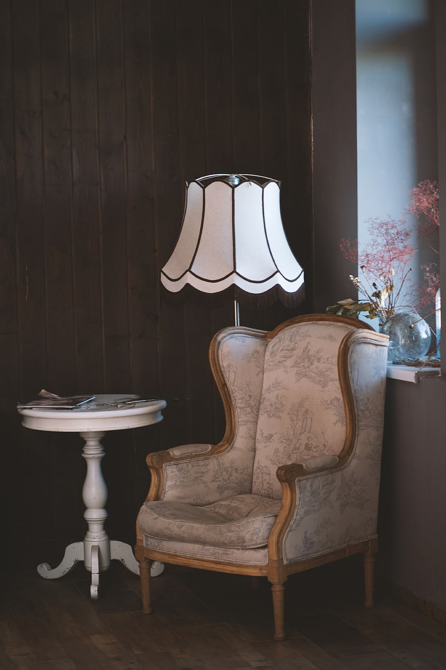 Vintage Wingback Armchair and Lamp in Dark Wood Room