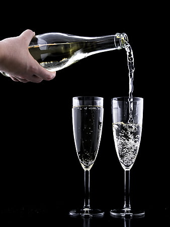 Pouring Champagne into Flutes on Black Background