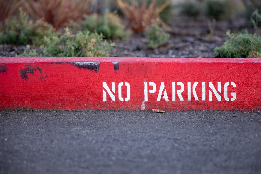 Red No Parking Curb with White Stenciled Text