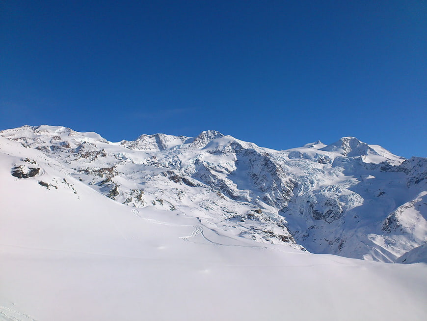 Snow-Covered Mountain Peaks Under Clear Blue Sky