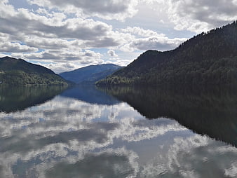 Serene Norwegian fjord landscape with cloud reflections