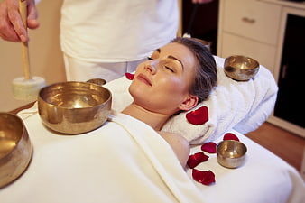 Woman receiving singing bowl sound healing therapy