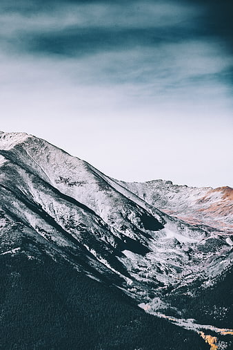 Snow-Capped Mountain Peak with Dramatic Cloudy Sky