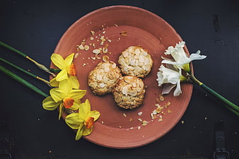 Almond cookies on terracotta plate with spring daffodils