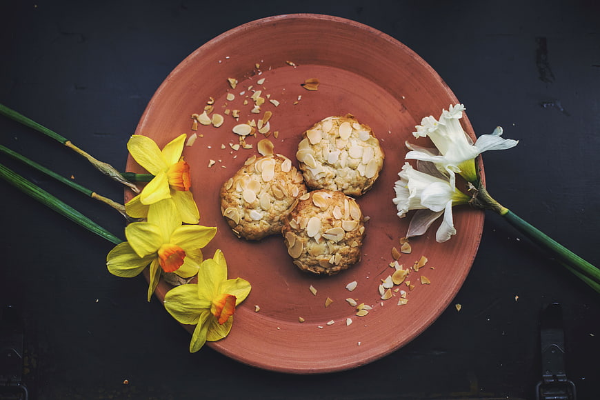 Almond cookies on terracotta plate with spring daffodils
