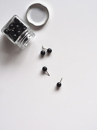 Minimalist Black Pins in Glass Jar on White Background