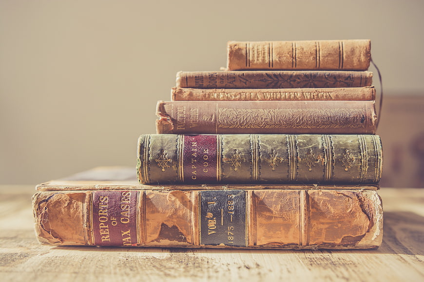 Stack of vintage antique books on wooden table