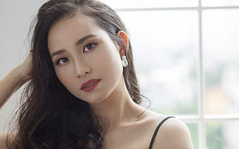 Portrait of a young Asian woman with long dark hair and red lipstick
