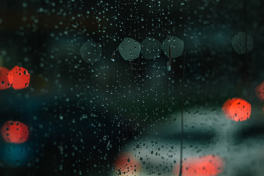 Raindrops on Window with Red Bokeh Lights