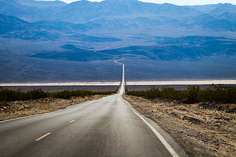 Straight Desert Highway Stretching to Distant Blue Mountains