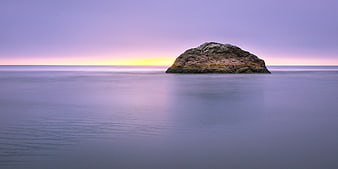 Serene Rock Island in Calm Ocean at Sunset