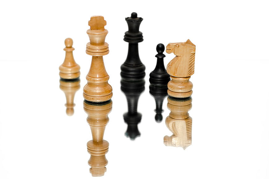 Wooden Chess Pieces on White Background with Reflection