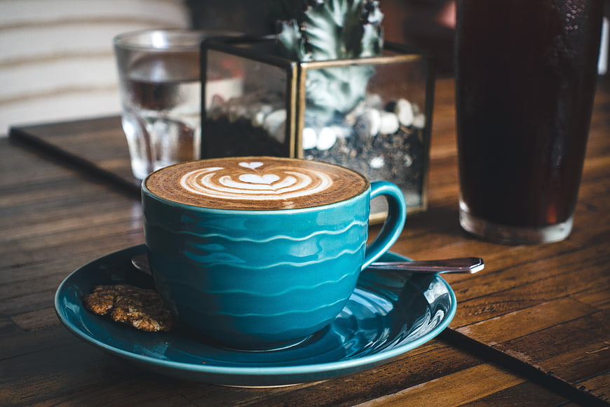Blue Cup of Cappuccino with Latte Art on Wooden Table