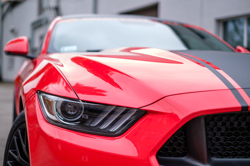 Close-up of Red Mustang Front Headlight and Hood