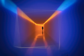 Silhouette of person walking in colorful neon tunnel