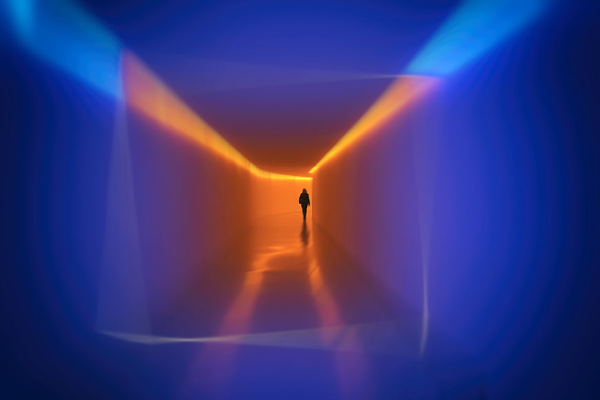 Silhouette of person walking in colorful neon tunnel
